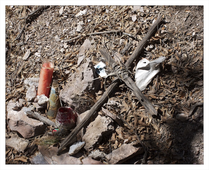  A cross made by a volunteer from the Tucson based charity ‘The Samaritans’ marks the grave of a Latin American migrant who died on the trail in the Tumacacori Mountains just west of Highway 19 and five miles from the border. There are many graves and shrines like this in the south western deserts. They are tended by American volunteers and migrants alike. Migrants will often forgo carrying precious life saving food and water so that they can carry candles and amulets to place on unmarked graves and shrines like this.&nbsp; 