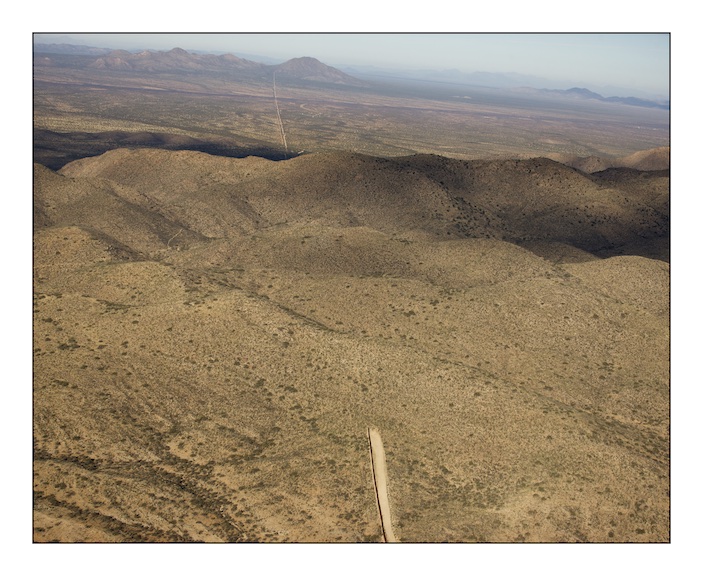  The border fence between Mexico (on the left) and the United States (on the right) stops abruptly as the Baboquivari Mountains rise out of the desert near the hard scrabble town of Sassabe that straddles the border in southern Arizona. The fence costs over one million dollars per mile and in areas where the terrain is especially harsh and dangerous to cross the construction halts. The consequence of this is that migrants are forced into areas where human life is incredibly difficult to sustain and they die.&nbsp; 